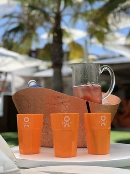 Three orange oCean Beach cups on a table
